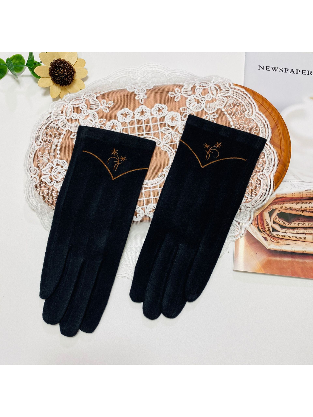 Black gloves with floral embroidery and a contrasting V-shaped cuff line