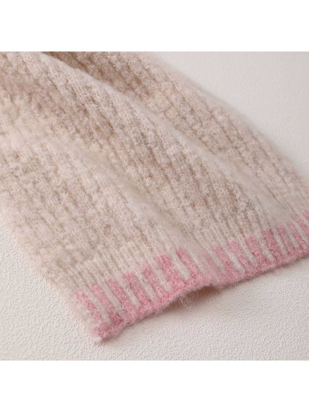 Close-up of beige ribbed texture and pink barred end border
