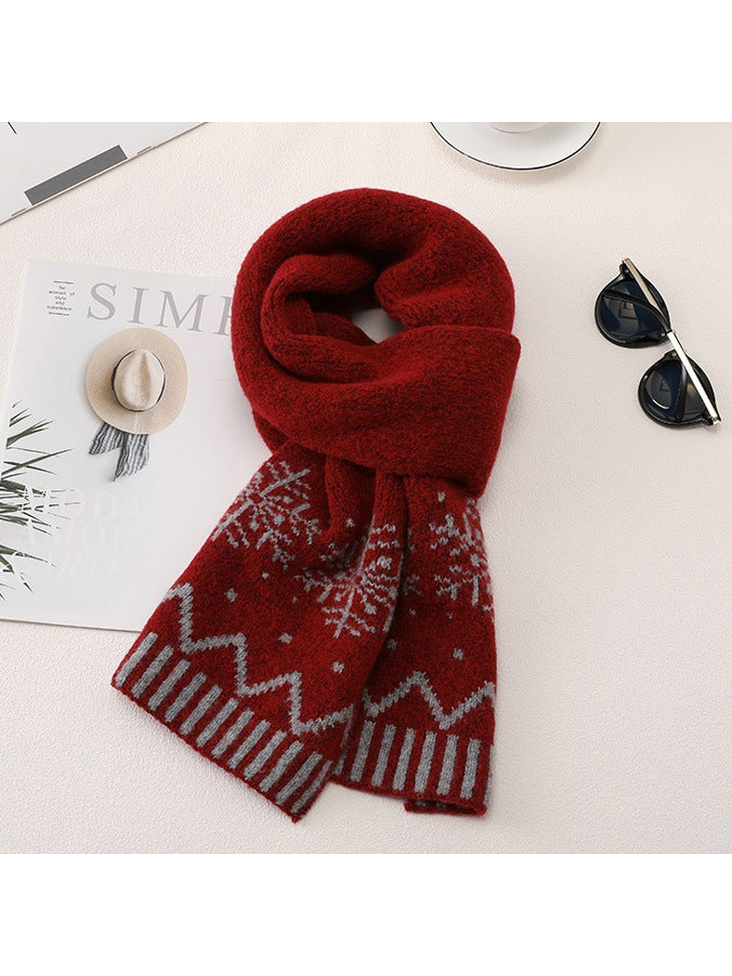 Red long scarf with snowflake motifs arranged with sunglasses