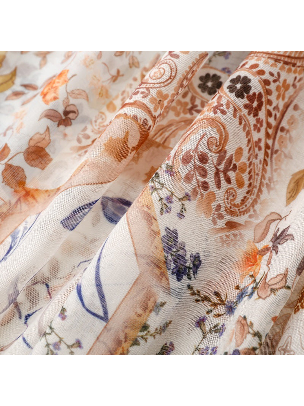 Close-up of layered floral, paisley and blue botanical motifs
