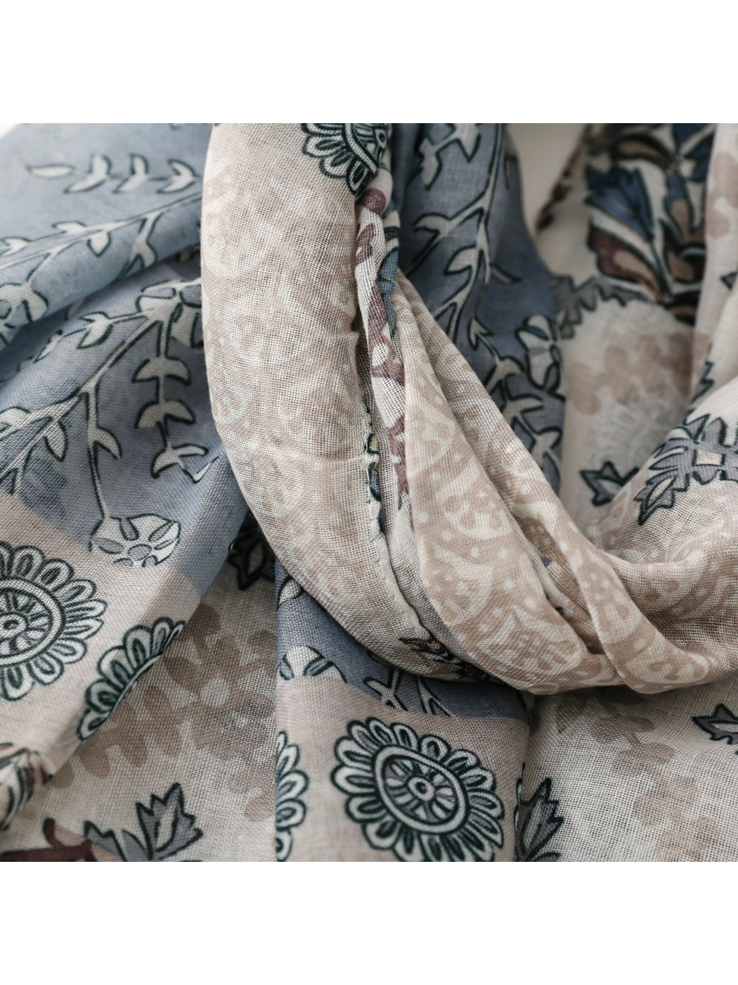 Close-up of layered blue-gray and beige patterned scarf panels