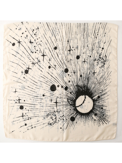 Ivory scarf laid flat with a black radiating celestial motif