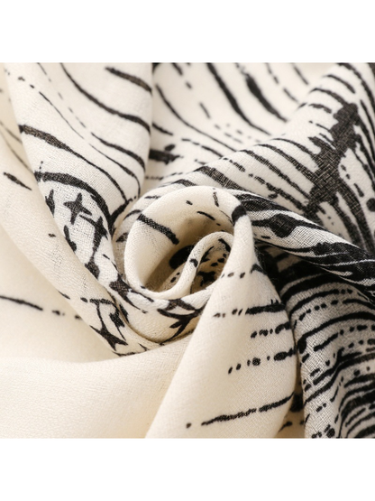 Close-up of the Ivory scarf's fine weave and black line print