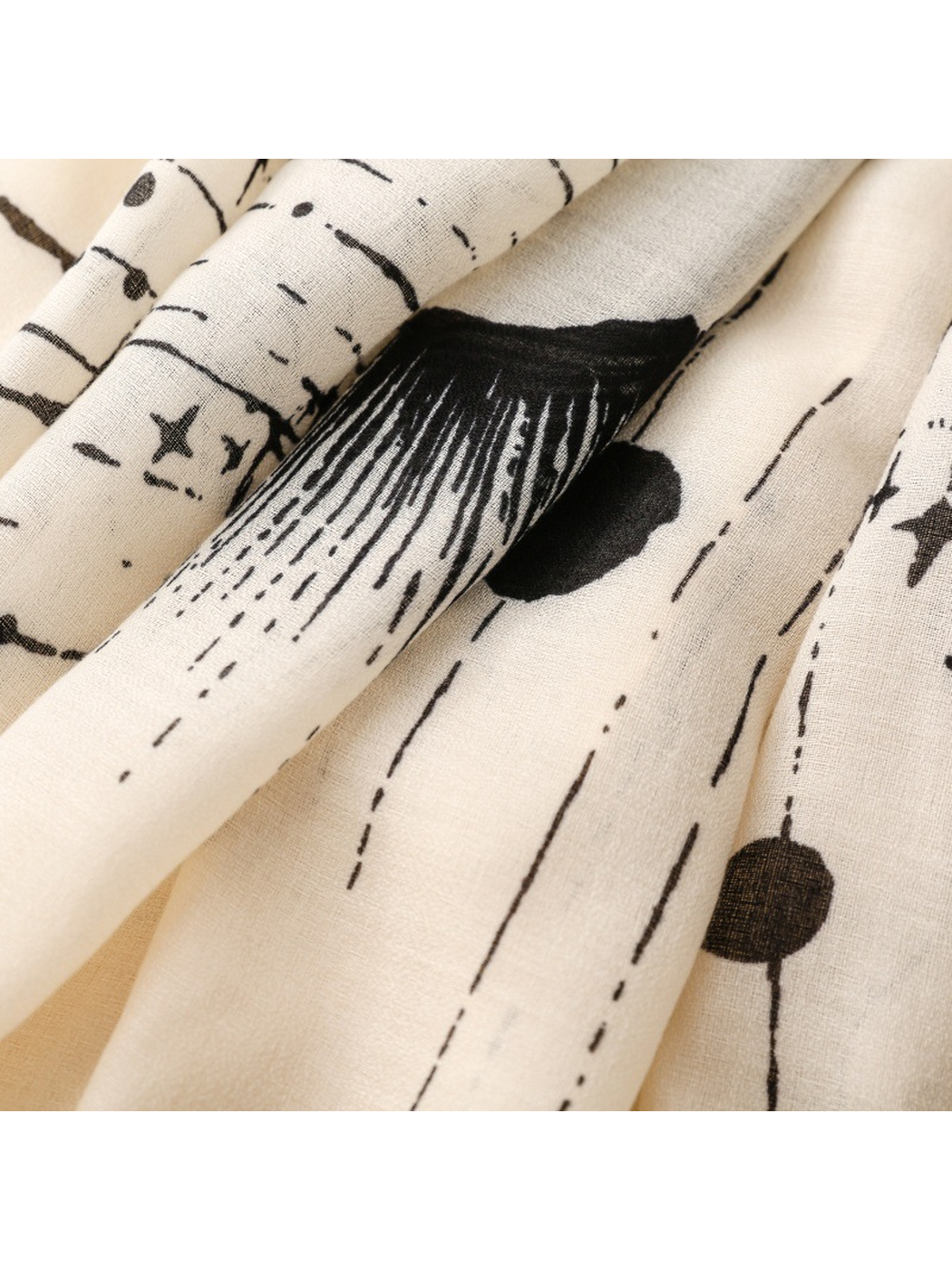Close-up of the Ivory scarf's radiating motif, dots, and fine weave