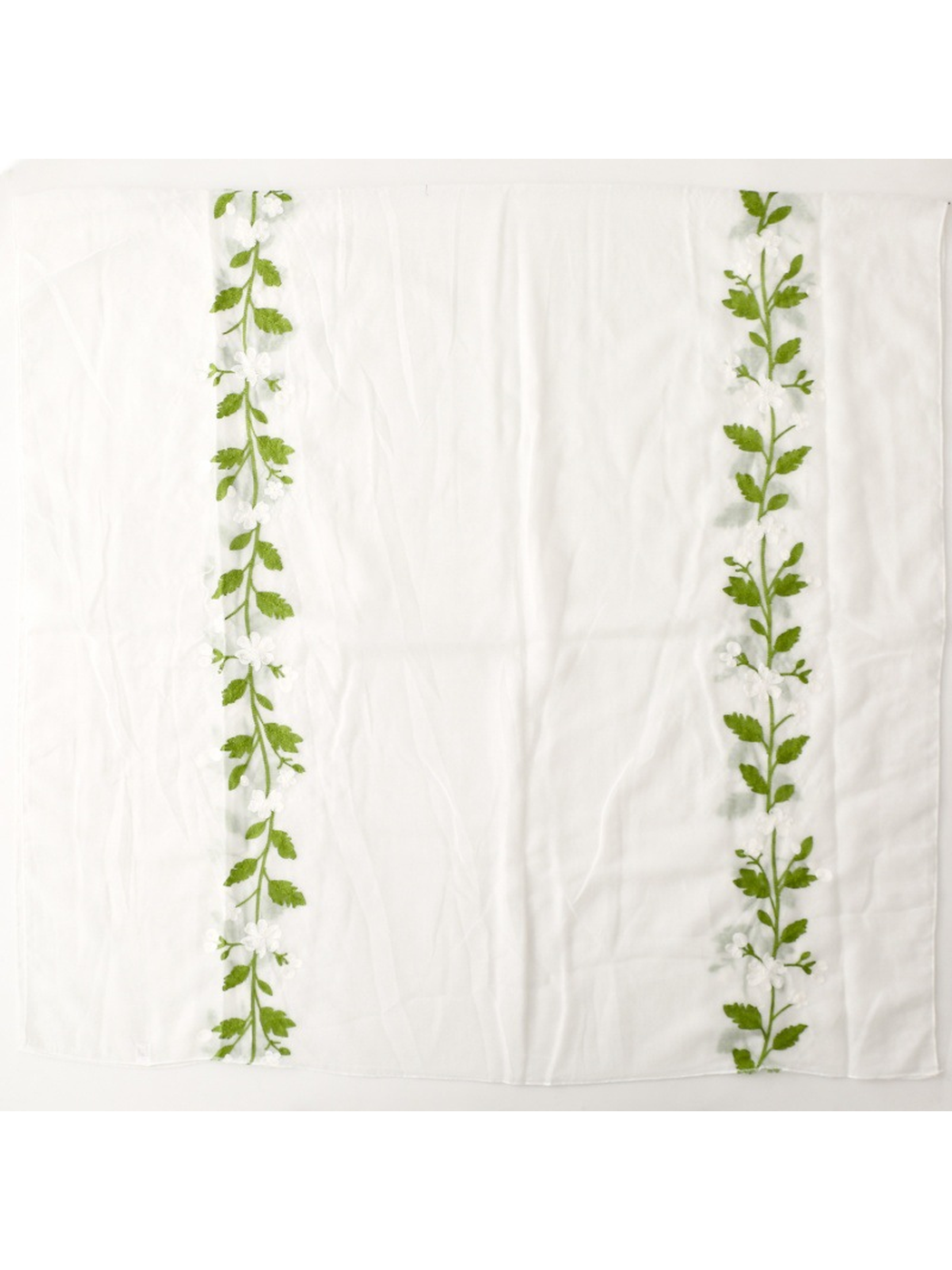 White scarf laid flat to show two embroidered floral vine panels