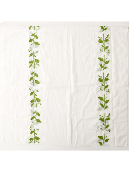 White scarf laid flat to show two embroidered floral vine panels
