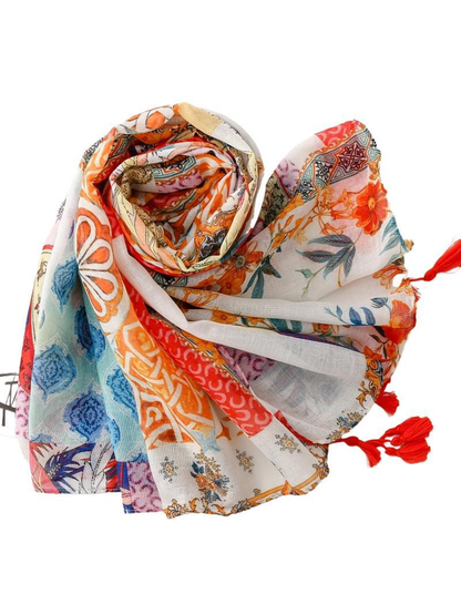 Multicolor patchwork scarf loosely rolled with patterned ends and red tassels