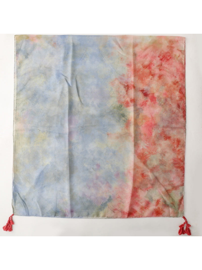 Multicolor abstract-pattern scarf laid flat with red corner tassels