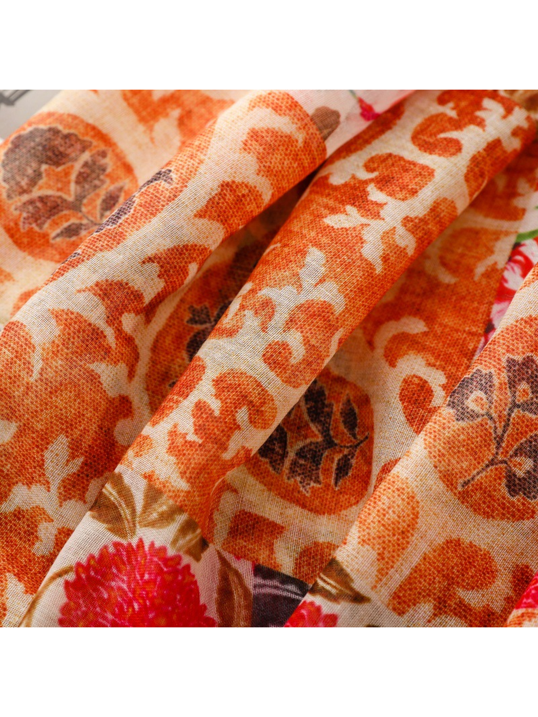 Close-up of the orange ornamental print and fine woven texture