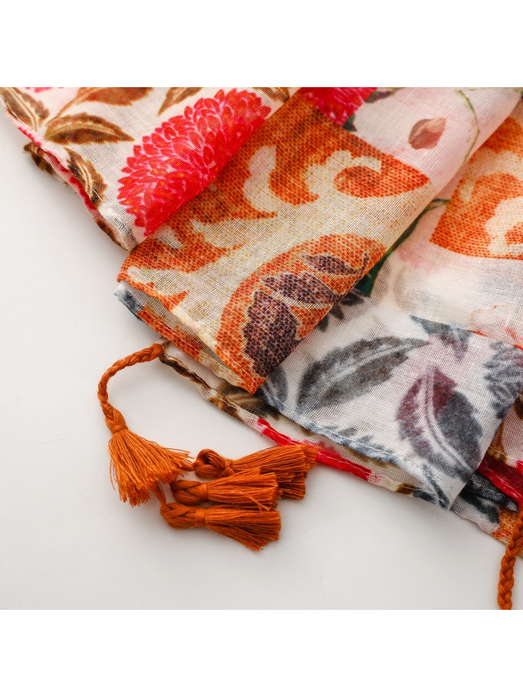 Close-up of the stitched scarf edge and rust-orange tassels