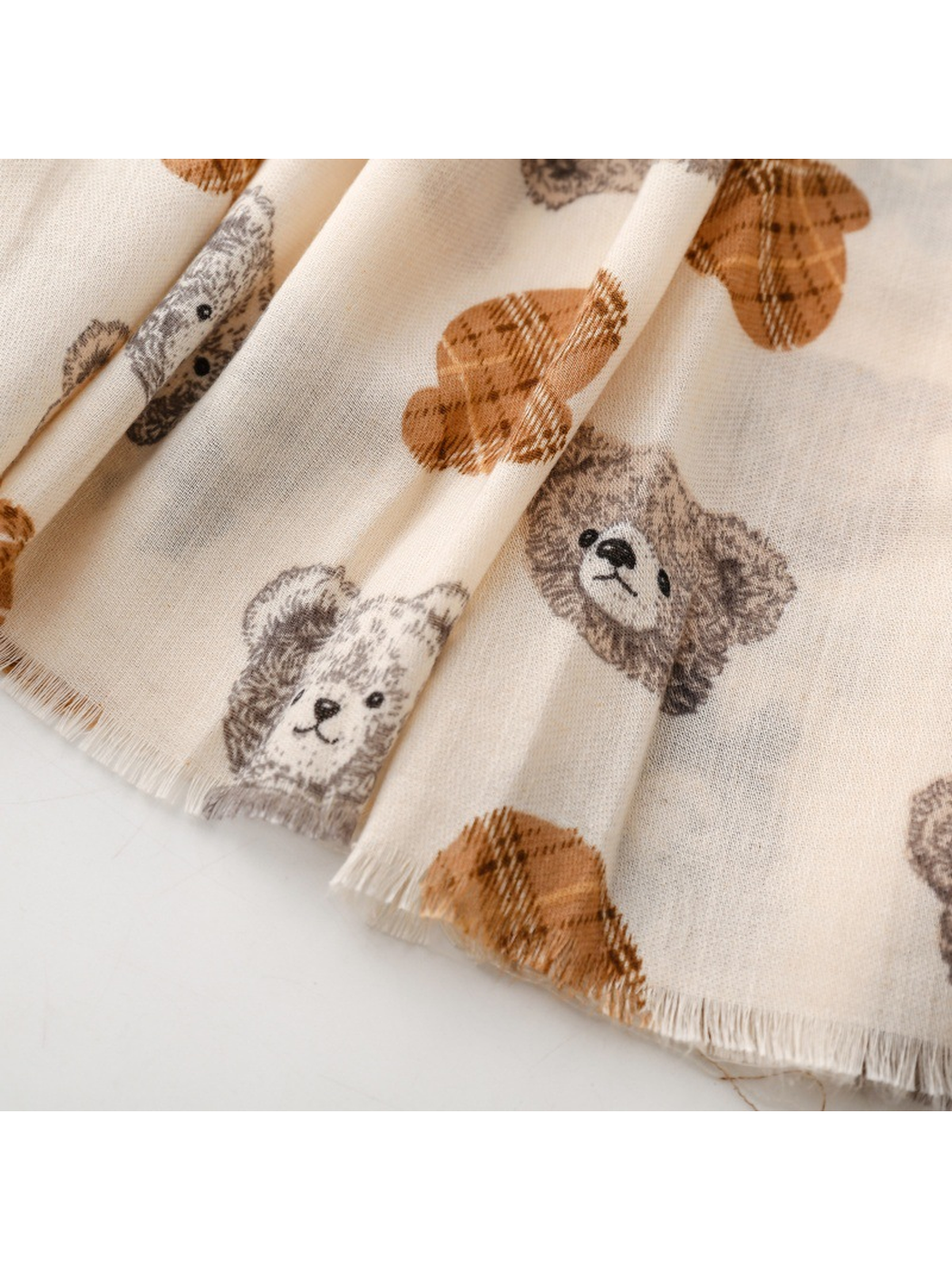 Close-up of the ivory scarf teddy bear print and short fringed edge
