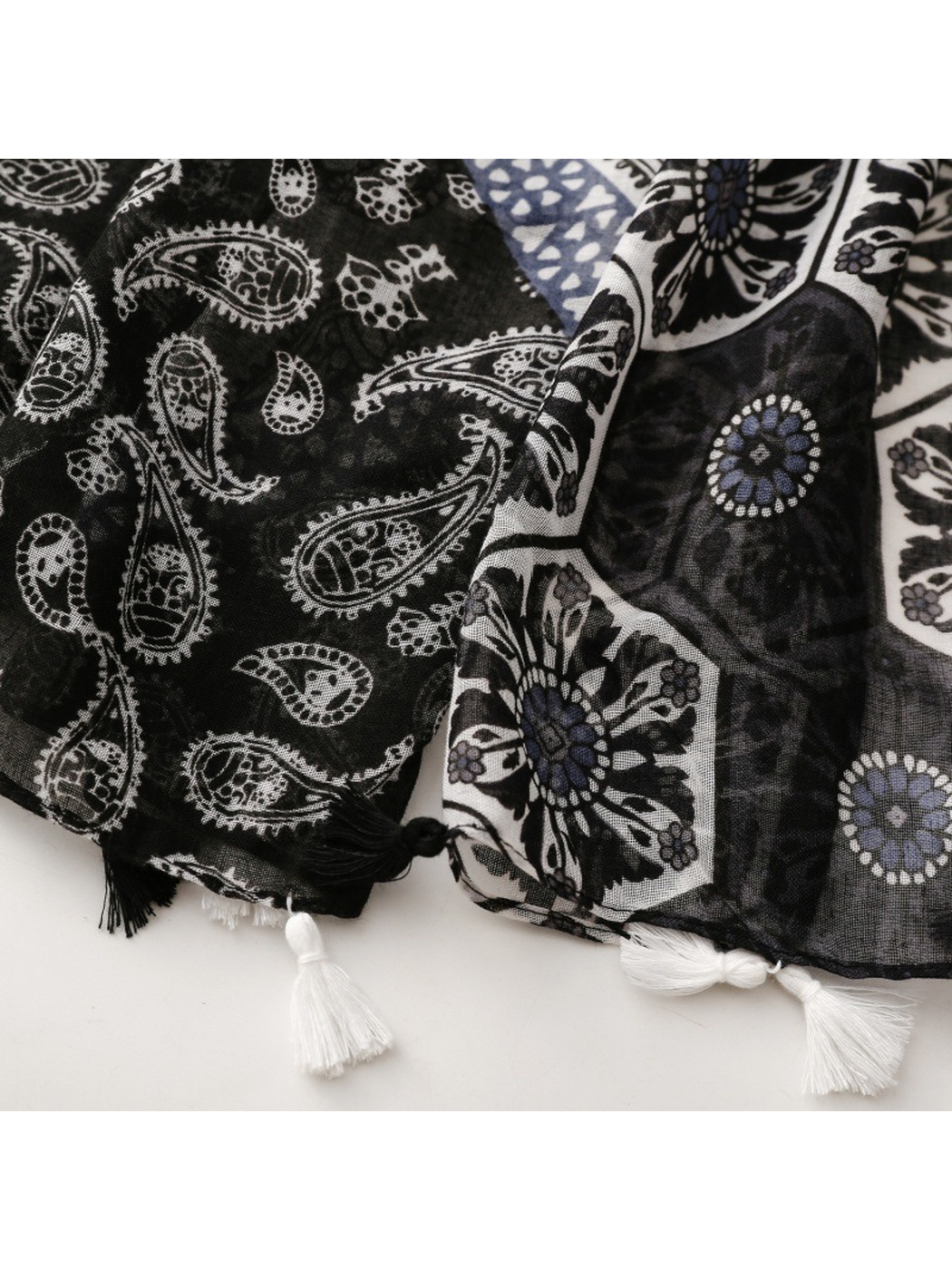 Close-up of paisley and floral patchwork with alternating black and white tassels