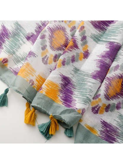 Close-up of the scarf's gray-green border and mustard and teal tassels