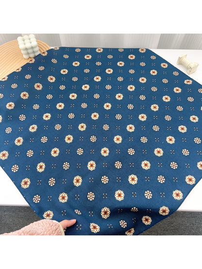 Blue medallion-pattern square scarf laid flat to show its full shape
