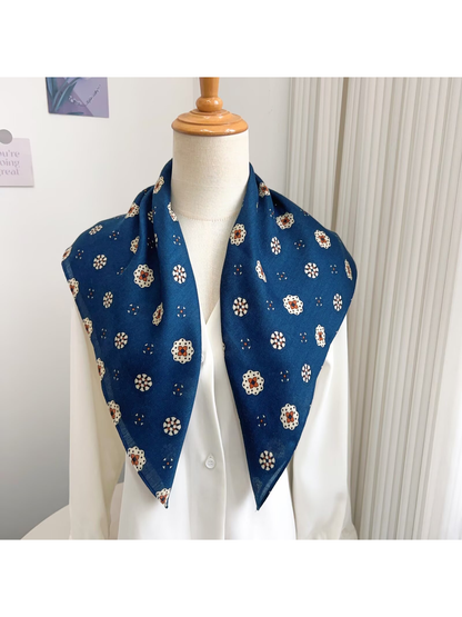 Blue medallion-pattern square scarf draped around a dress form