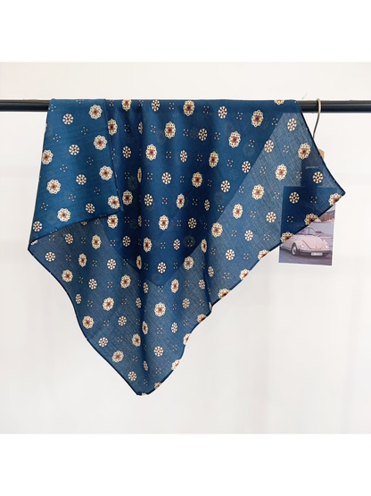 Blue medallion-pattern square scarf draped over a display rail