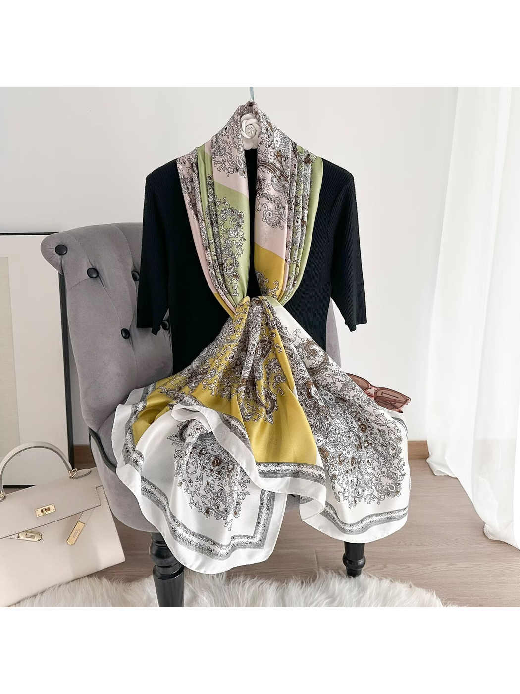 Light green, mustard and ivory paisley scarf looped and knotted over a chair