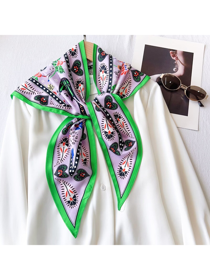 Light purple and green triangle scarf knotted over a white blouse