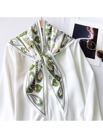 White and olive triangle scarf knotted over a white blouse