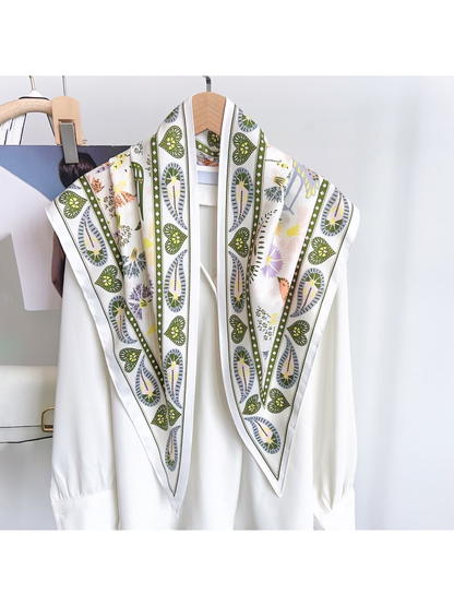White triangle scarf with olive border draped over a white blouse
