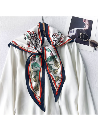 Navy-border floral and equestrian-print triangle scarf tied over a white blouse