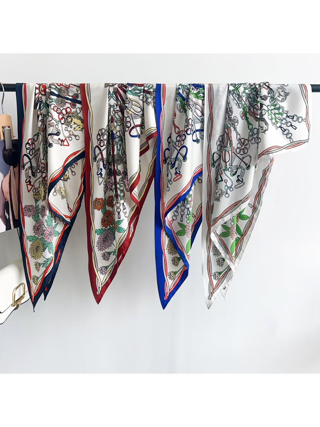 Floral and equestrian-print triangle scarves in multiple border colors displayed together