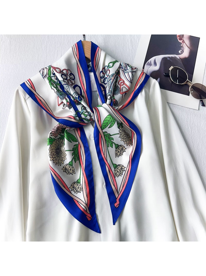 Blue-border floral and equestrian-print triangle scarf tied over a white blouse