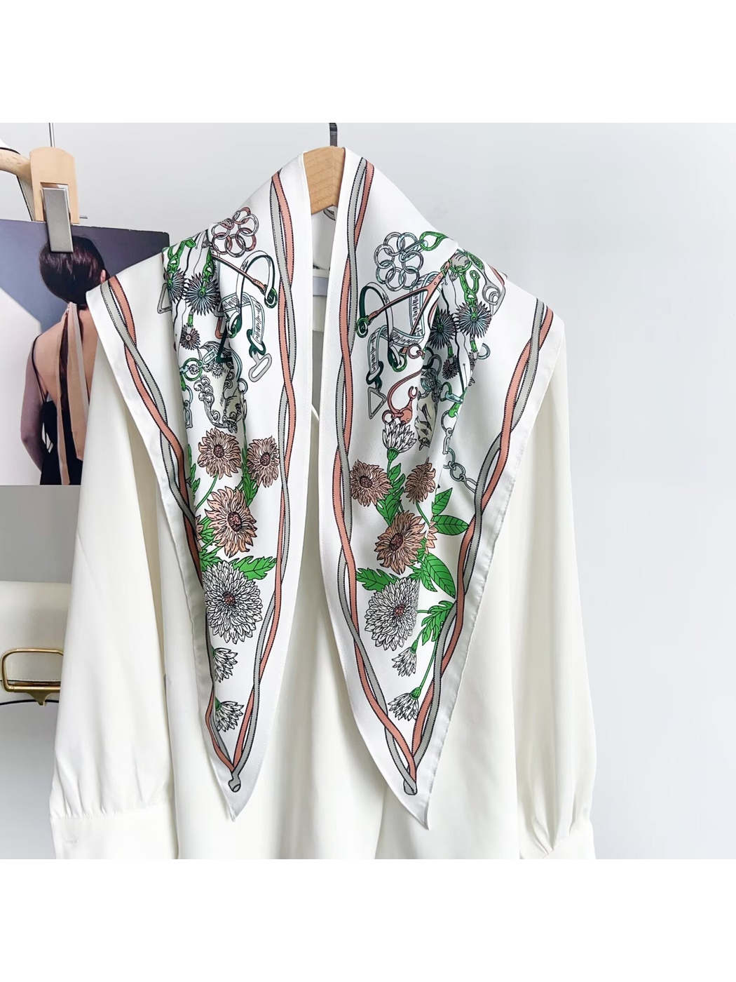 White triangle scarf with blush trim draped over a blouse to show the floral and equestrian print