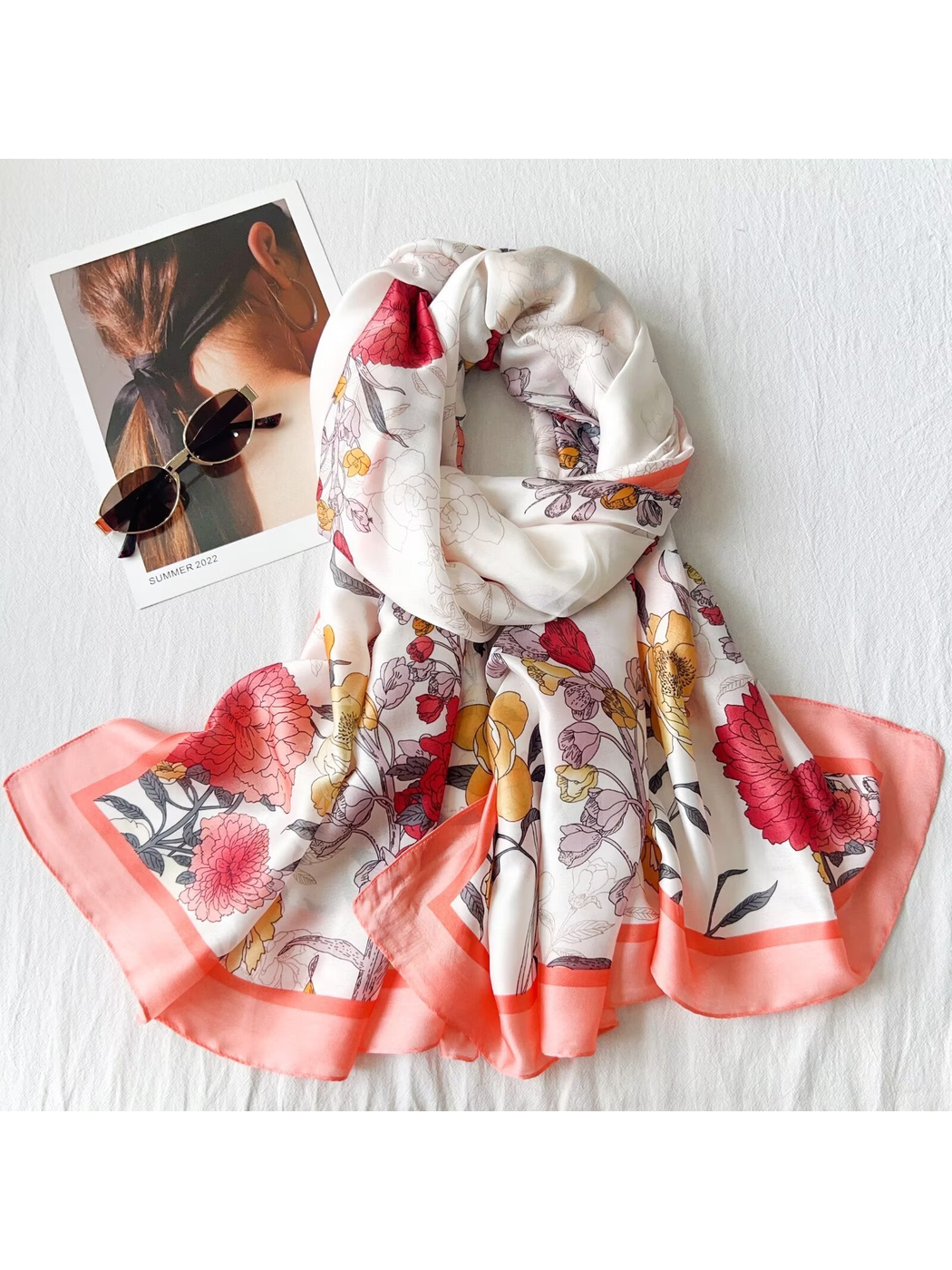 Multicolor floral scarf arranged in a dimensional drape with sunglasses