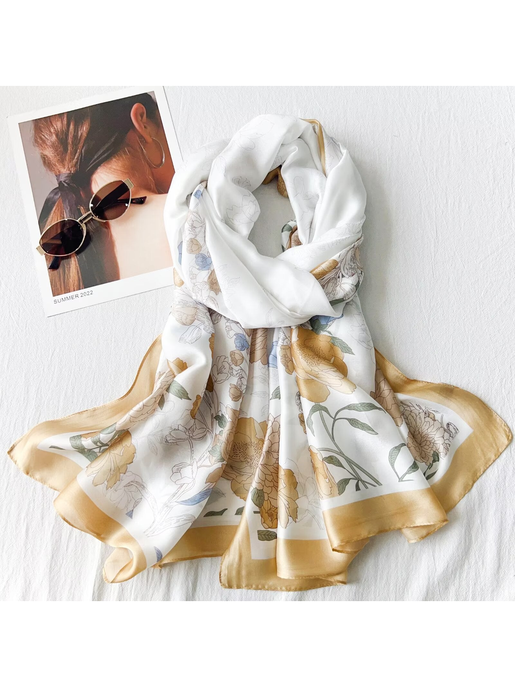 Gold floral scarf arranged in a dimensional drape with sunglasses