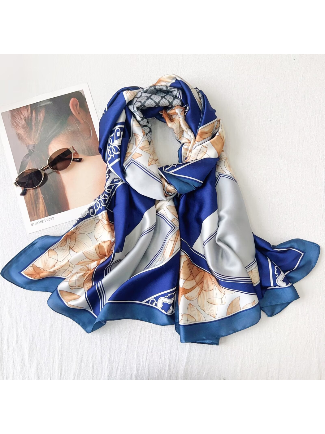 Blue floral long rectangular scarf arranged in a dimensional drape with sunglasses