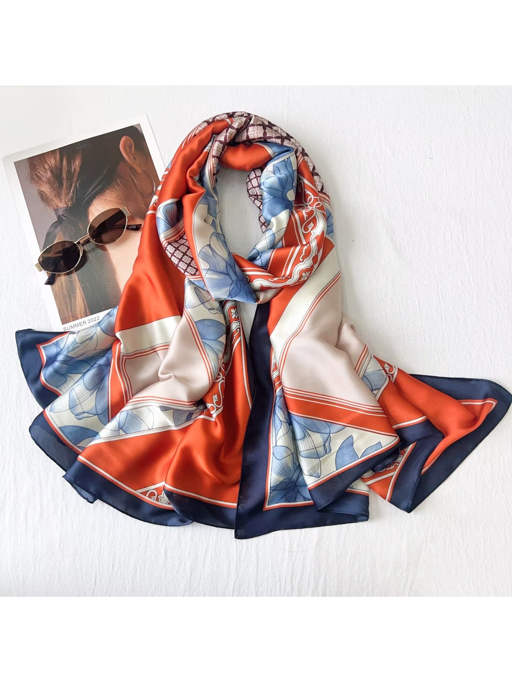 Orange-red and blue floral long rectangular scarf arranged in a dimensional drape