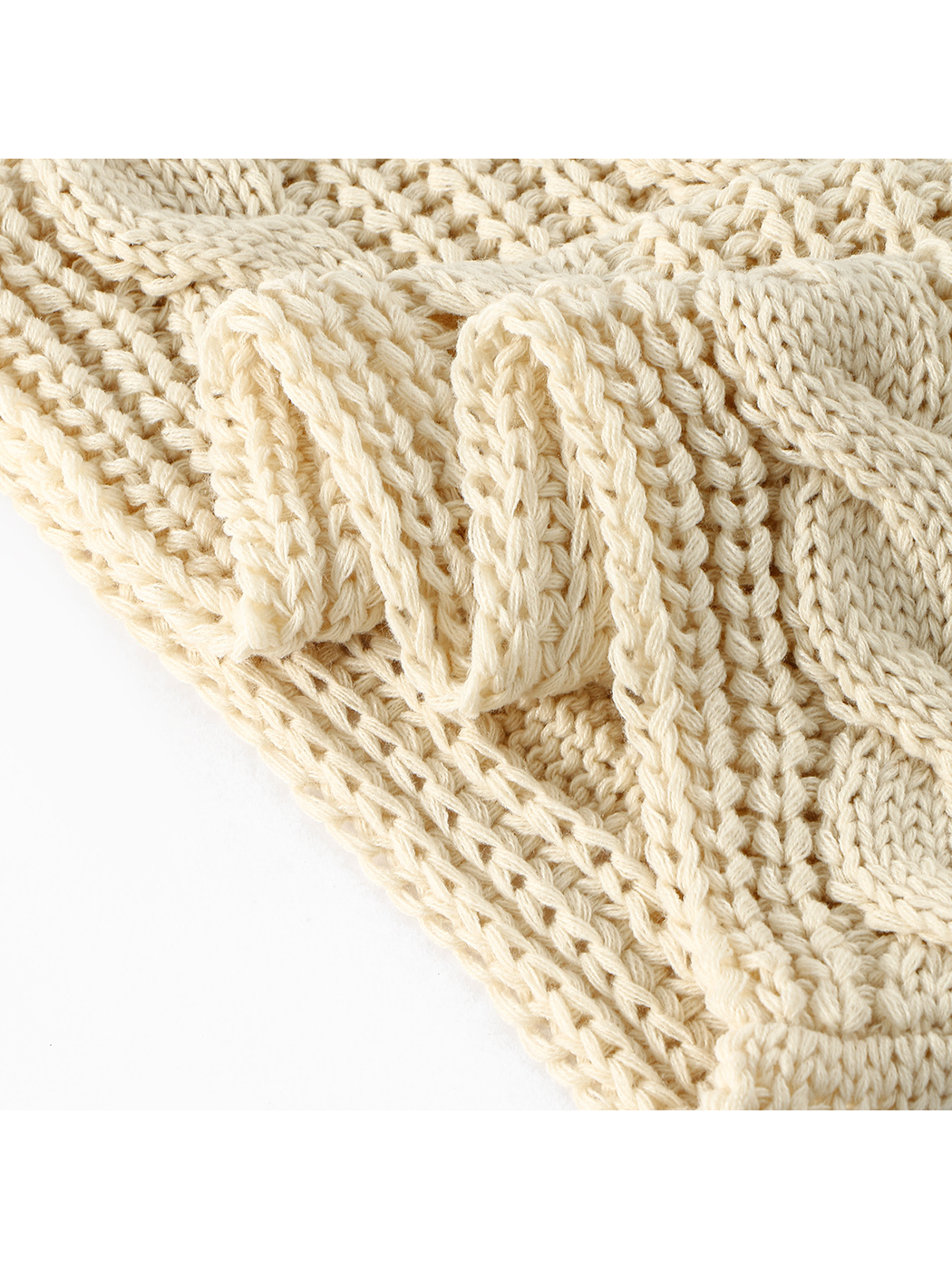 Close-up of the cream cable pattern and joined loop edge