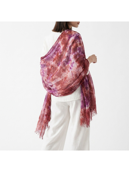 Purple and burgundy abstract-pattern scarf wrapped across a model's back
