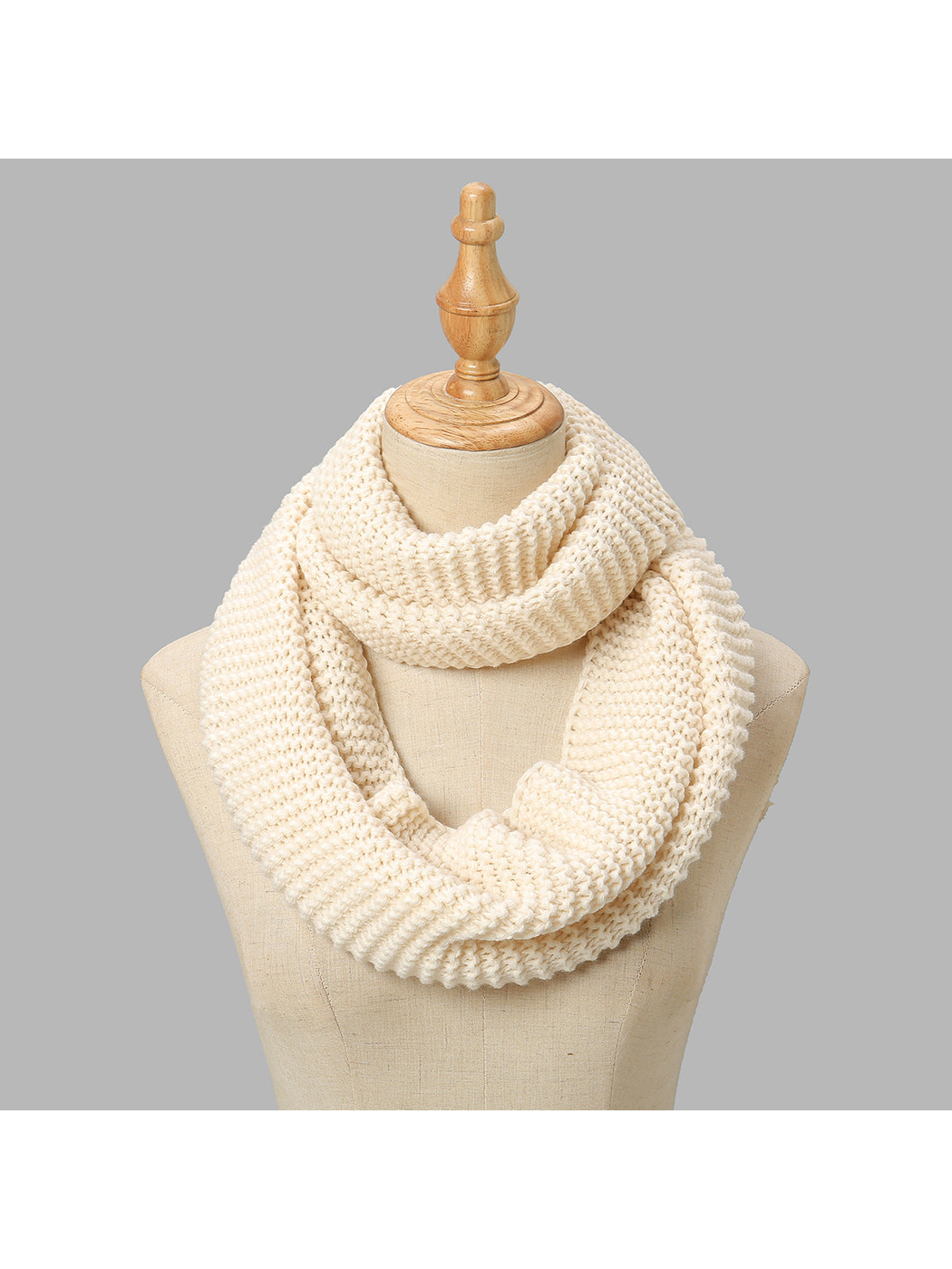 Beige chunky knit infinity scarf draped on a display form
