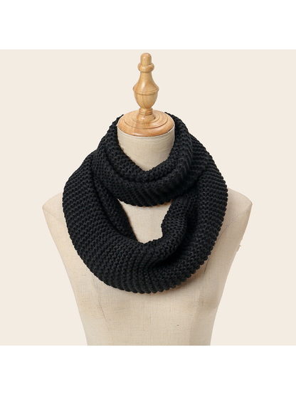 Black chunky knit infinity scarf draped on a display form