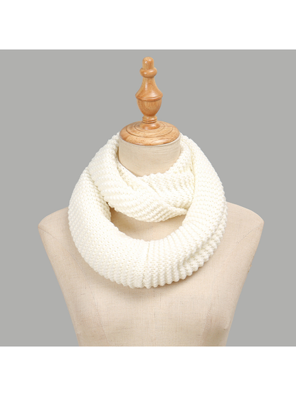 White chunky knit infinity scarf draped on a display form