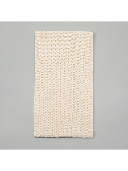 Beige knit infinity scarf laid flat to show its rectangular loop shape