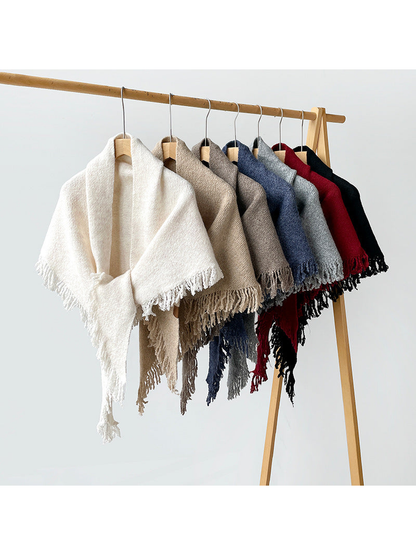 Seven solid-color fringed scarves hanging together