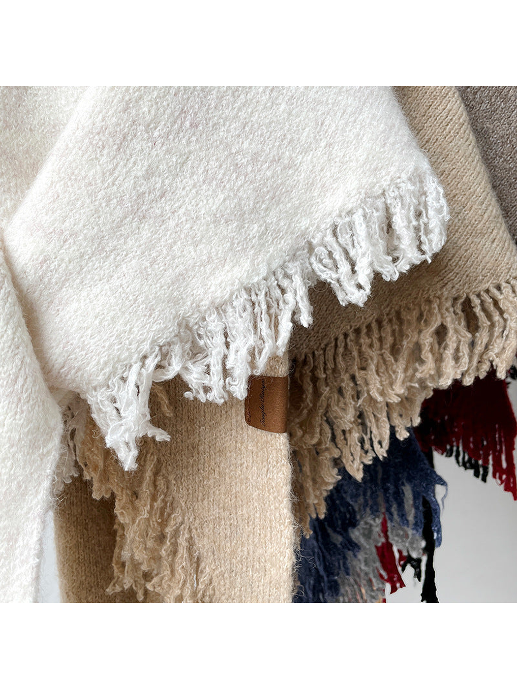 Close-up of textured scarf surfaces and fringed edges
