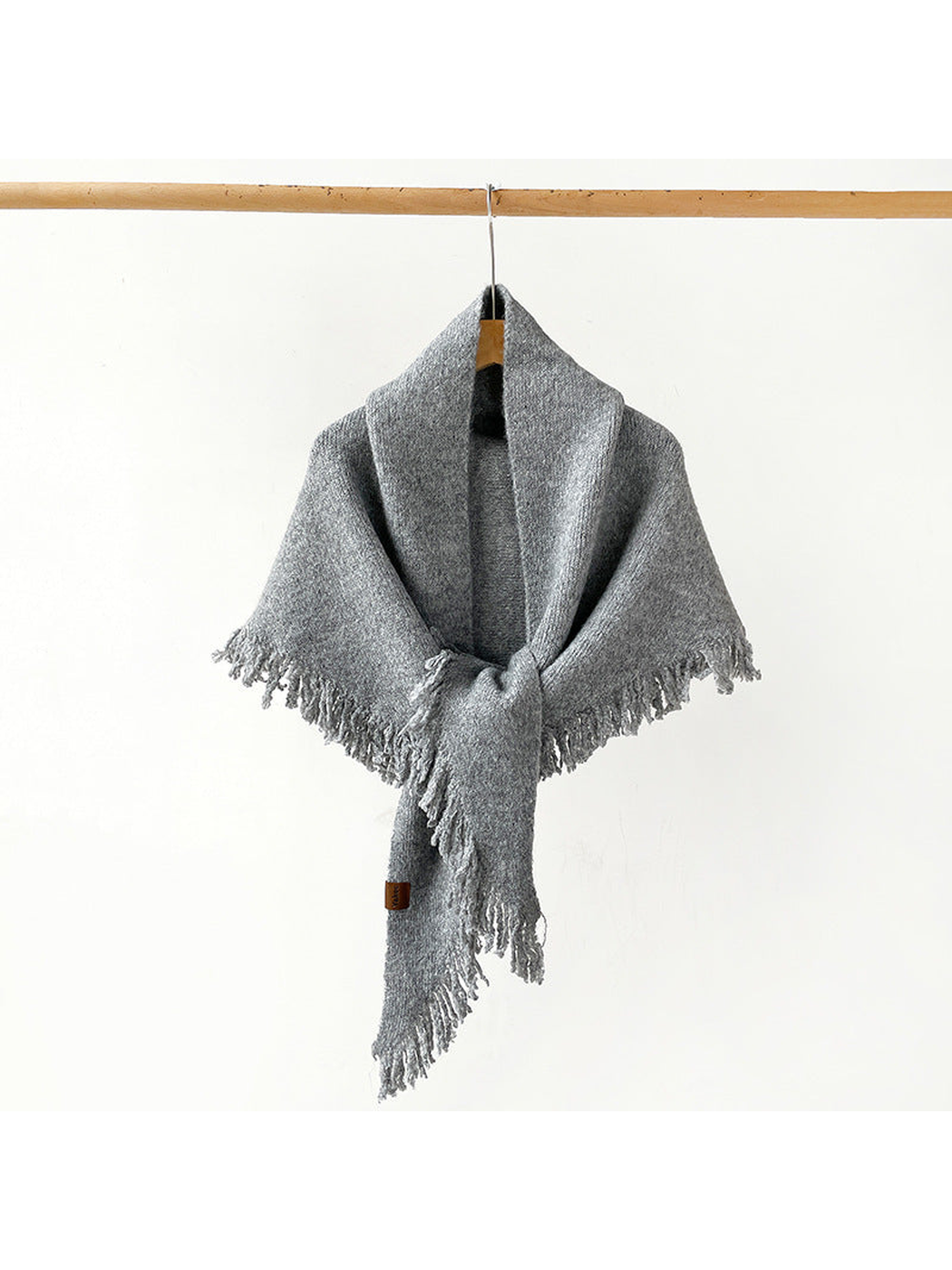 Heather Gray fringed scarf draped and knotted on a hanger