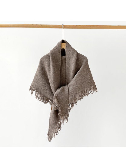 Brown fringed scarf draped and knotted on a hanger