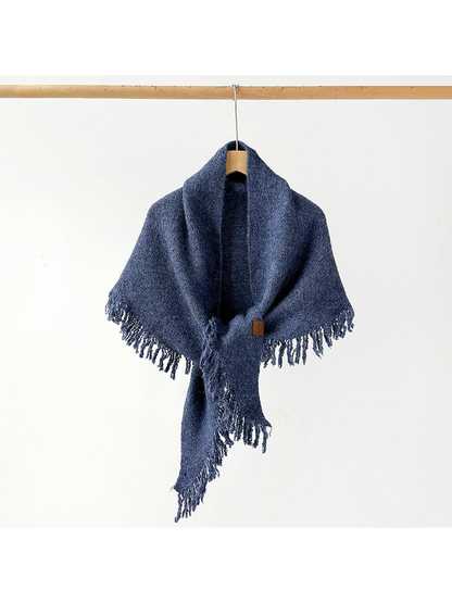 Navy fringed scarf draped and knotted on a hanger
