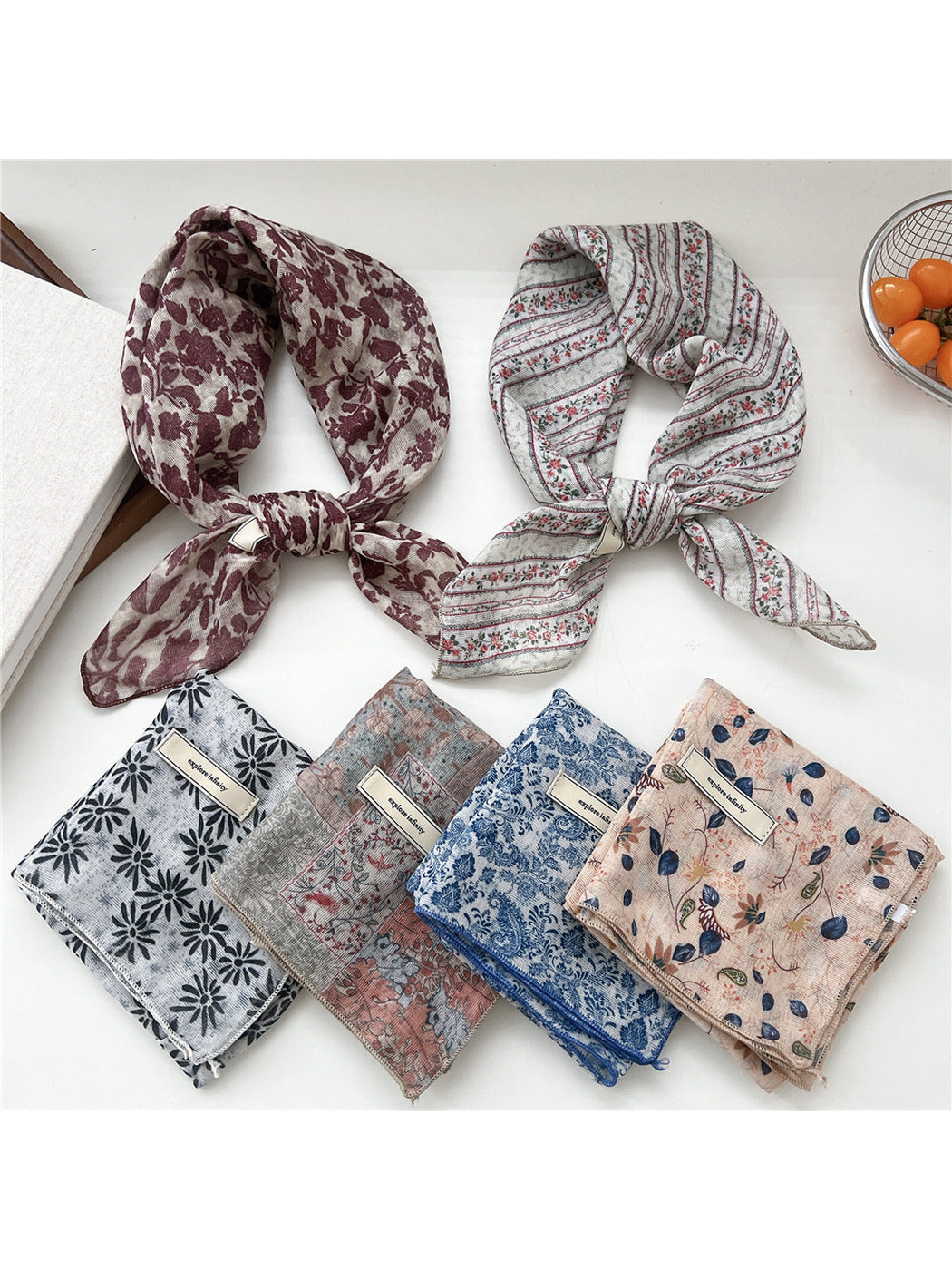 Floral square scarves displayed in tied and folded arrangements