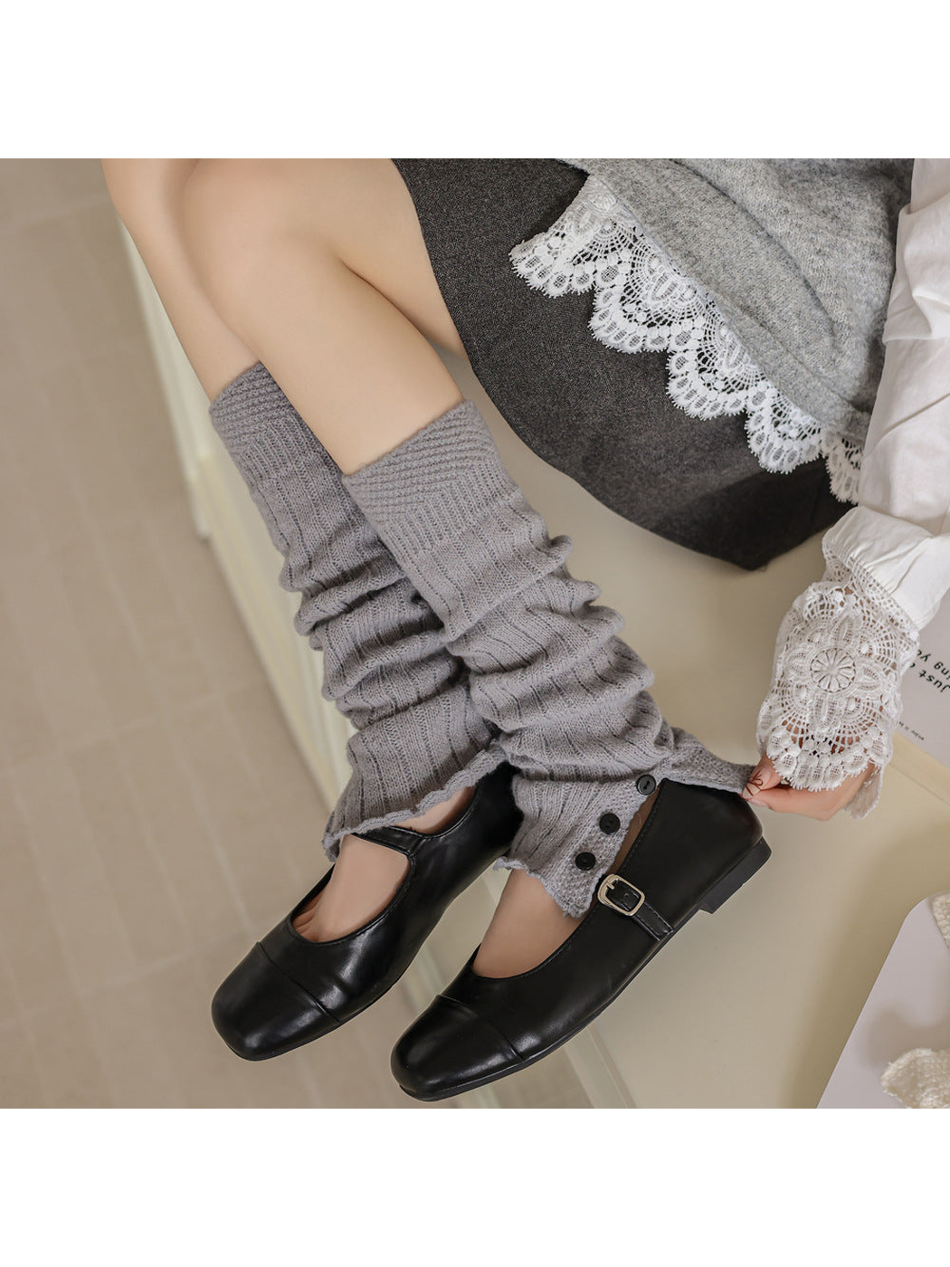 Gray ribbed leg warmers with split button-trimmed lower edges worn with black shoes.