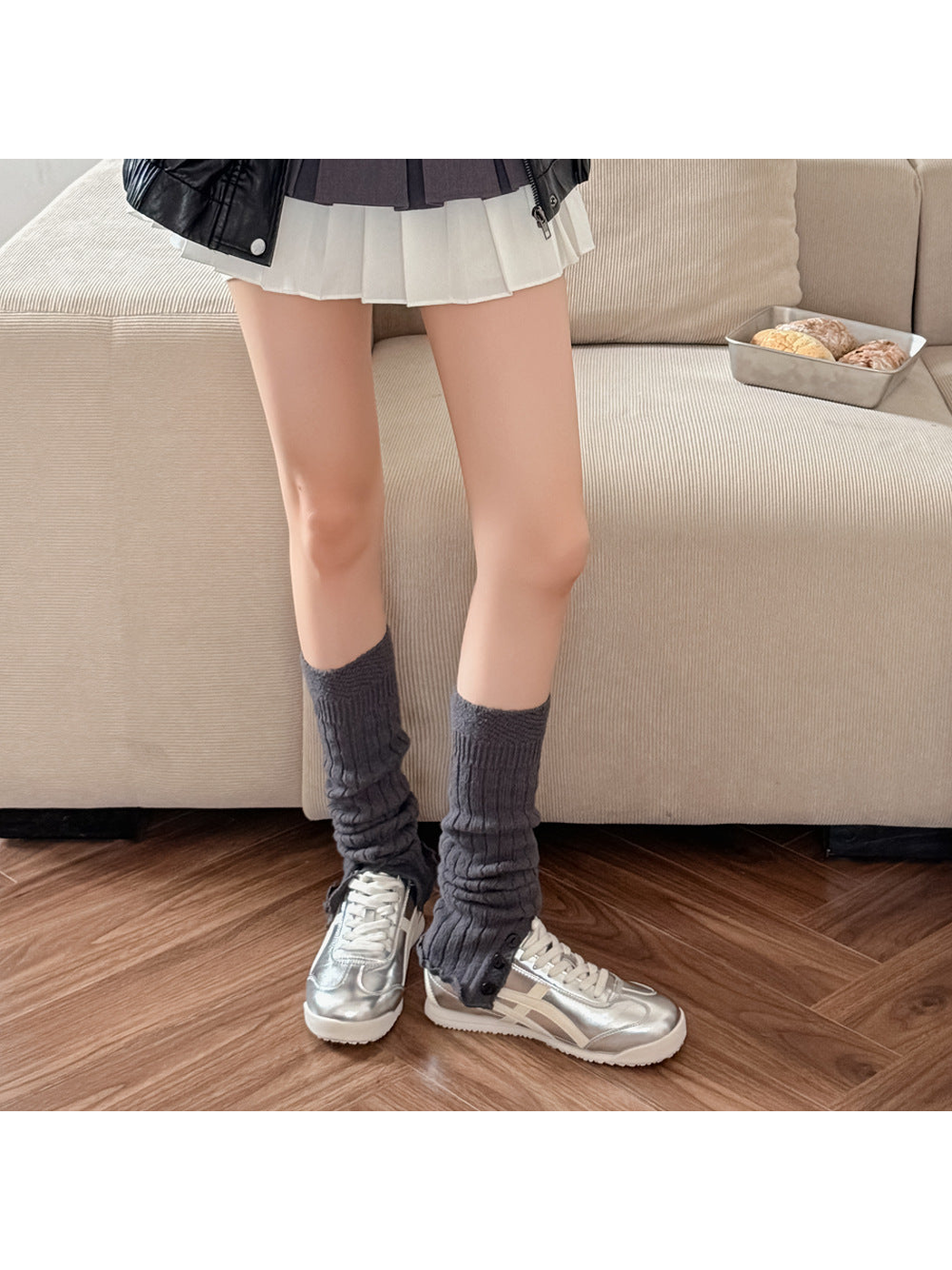Dark gray ribbed leg warmers worn with silver sneakers.
