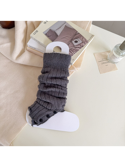 Dark gray ribbed leg warmer with a textured cuff and black button trim.