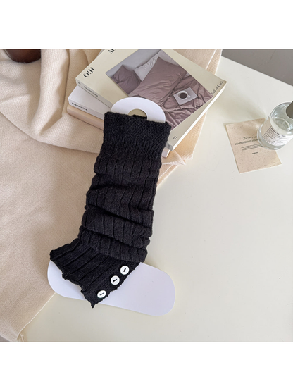 Black ribbed leg warmer with a textured cuff and contrasting button trim.