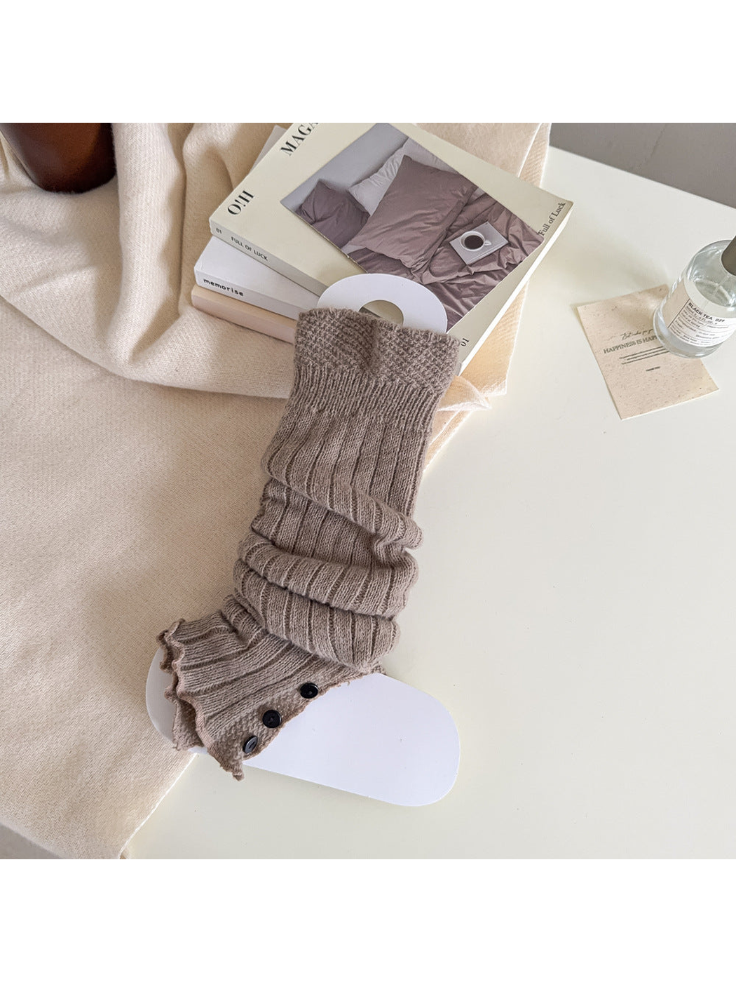 Greige ribbed leg warmer with a textured cuff and black button trim.