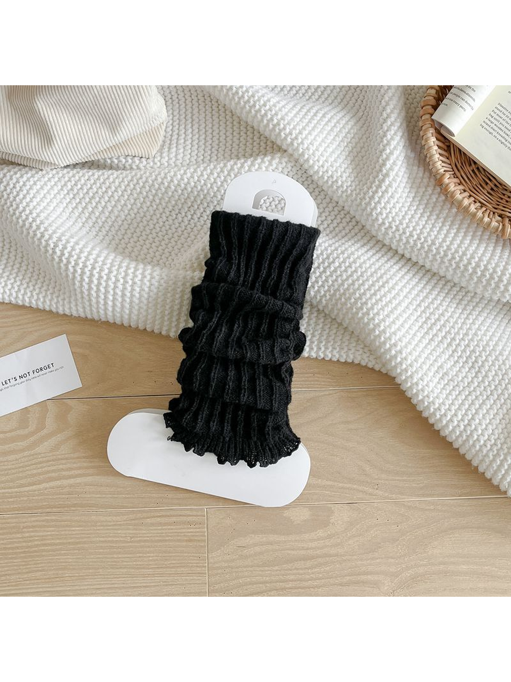 Black ribbed leg warmers with a ruffled edge